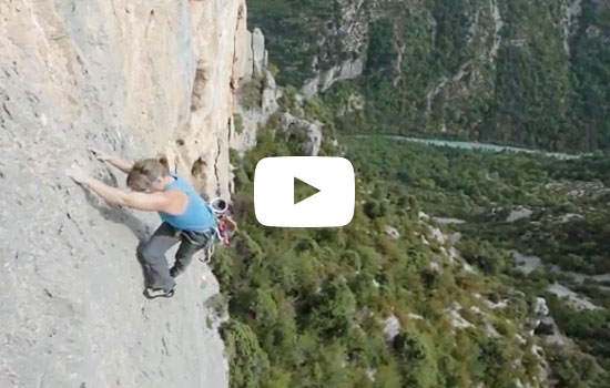 A woman climbing a steep rock wall